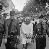 Pablo Picasso joking around with policemen before the corrida put on in his honor. On the left Jacqueline. Vallauris 1955. - Photo by Edward Quinn