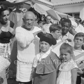 Pablo Picasso dresses up his children Paloma Picasso and Claude Picasso in miniature toreador costumes. In front of restaurant Le Vallauris. Vallauris 1955. - Photo by Edward Quinn