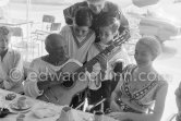 Local Corrida. Restaurant Le Vallauris. Pablo Picasso with guitar. Francine Weisweiller, right Dr. Jeanne Creff (acupuncturist of Pablo Picasso). Vallauris 11.8.1955. - Photo by Edward Quinn
