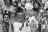 On the grandstand of a bullfight put on in Pablo Picasso's honor. From left: Jacqueline, Pablo Picasso, Jean Cocteau. Behind them Paloma Picasso, Maya Picasso and Claude Picasso. Vallauris 1955. - Photo by Edward Quinn