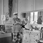 To strike a pose, Pablo Picasso tries on hats from his collection for his own amusement and that of his guests. La Californie, Cannes 1956. - Photo by Edward Quinn