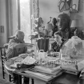 Pablo Picasso and Jacqueline. Luncheon at the dining and work table. Jacqueline is wearing a dress with printed motifs of a Pablo Picasso work. La Californie, Cannes 1956. - Photo by Edward Quinn