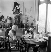 Pablo Picasso and Jacqueline. Luncheon at the dining and work table. Jacqueline is wearing a dress with printed motifs of a Pablo Picasso work. La Californie, Cannes 1956. - Photo by Edward Quinn