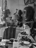 Jacqueline. Luncheon at the dining and work table. Jacqueline is wearing a dress with printed motifs of a Picasso work. La Californie, Cannes 1956. - Photo by Edward Quinn