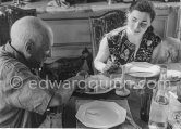 Pablo Picasso and Jacqueline. Luncheon at the dining and work table. Jacqueline is wearing a dress with printed motifs of a Pablo Picasso work. La Californie, Cannes 1956. - Photo by Edward Quinn