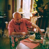 Pablo Picasso and Jacqueline. Luncheon at the dining and work table. Jacqueline is wearing a dress with printed motifs of a Pablo Picasso work. La Californie, Cannes 1956. - Photo by Edward Quinn