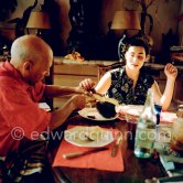 Pablo Picasso and Jacqueline. Luncheon at the dining and work table. Jacqueline is wearing a dress with printed motifs of a Pablo Picasso work. La Californie, Cannes 1956. - Photo by Edward Quinn