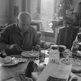 Pablo Picasso and Jacqueline. Luncheon at the dining and work table. Jacqueline is wearing a dress with printed motifs of a Pablo Picasso work. La Californie, Cannes 1956. - Photo by Edward Quinn
