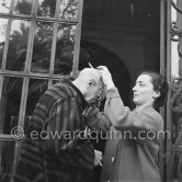 To enhance the effect of a new veluet blouse given him for his birthday, Pablo Picasso wears one of Jacqueline's necklaces and mimes what he imagines to be the appropriate expression for an ancient emperr. On the occasion of his 75th birthday on 25.10. La Californie, Cannes 1956. - Photo by Edward Quinn