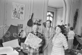 Pablo Picasso with a book about Bernard Palissy, French potter of the 16th century. Pierre-André and Lucie Weill. Jacqueline, Georges and Suzanne Ramié in the background. La Californie, Cannes 1957. - Photo by Edward Quinn