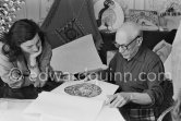 Picasso and Jacqueline viewing a book about Bernard Palissy, French potter of the 16th century. La Californie, Cannes 1957. - Photo by Edward Quinn