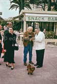 Pablo Picasso signing a cheque, Jacqueline and Félix Cenci. Dachshund Lump. In front of restaurant Chez Félix. Cannes 1958. - Photo by Edward Quinn