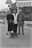 Pablo Picasso, Jacqueline and Félix Cenci. Dachshund Lump. In front of restaurant Chez Félix. Cannes 1958. - Photo by Edward Quinn