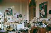 Dining table and sideboard are crowded with a fascinating mixture of objects and papers. On the walls hang two early portraits of Jacqueline dating from 1954. This corner of the living room gives an idea of Pablo Picasso's orderly disorder. La Californie, Cannes 1959. - Photo by Edward Quinn