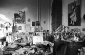Dining table and sideboard are crowded with a fascinating mixture of objects and papers. On the walls hang two early portraits of Jacqueline dating from 1954. This corner of the living room gives an idea of Pablo Picasso's orderly disorder. La Californie, Cannes 1959. - Photo by Edward Quinn