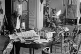 Pablo Picasso correcting a print. With Jacqueline (wearing a blouse with Pablo Picasso motifs). A pile of books: Level, André: Souvenirs d'un colectionneur. Avec en frontispice un lithographie originale de Pablo Picasso (les saltimbanques). A.C. Mazo, Paris 15.10.1959. La Californie, Cannes 1959. - Photo by Edward Quinn