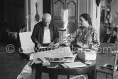 Pablo Picasso correcting "Faunes et chèvres". With Jacqueline (wearing a blouse with Pablo Picasso motifs). A pile of books Level, André: Souvenirs d'un colectionneur. Avec en frontispice un lithographie originale de Pablo Picasso (les saltimbanques). A.C. Mazo, Paris 15.10.1959. La Californie, Cannes 1961. - Photo by Edward Quinn