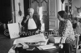 Pablo Picasso correcting "Faunes et chèvres". With Jacqueline (wearing a blouse with Pablo Picasso motifs).Bull mask in the background. A pile of books Level, André: Souvenirs d'un colectionneur. Avec en frontispice un lithographie originale de Pablo Picasso (les saltimbanques). A.C. Mazo, Paris 15.10.1959. La Californie, Cannes 1961. - Photo by Edward Quinn