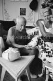A piece of sugar for Perro. On the right beside Pablo Picasso the wife of Spanish painter Antoni Clavé. La Californie, Cannes 1961. - Photo by Edward Quinn