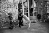 Jacqueline behind the window. Pablo Picasso with Kaboul on the terrace in front of the entrance to Mas Notre Dame de Vie. Because this house also quickly became too small, Pablo Picasso had a room built onto the terrace. Le Mas Notre-Dame-de-Vie, Mougins 1962. - Photo by Edward Quinn