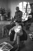 Picasso and Jacqueline with Afghan dog Kaboul and dachshund Lump. In the foreground a newspaper with an article "I teach my children to draw". With the photo Pic530342, "Leçon de dessin" or "Paysage (Avec Paloma Picasso, Claude Picasso et Françoise)", 1953. Mas Notre-Dame-de-Vie, Mougins 14.2.1962. - Photo by Edward Quinn
