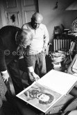Pablo Picasso and Siegfried Rosengart viewing a portfolio with early works. Mas Notre-Dame-de-Vie, Mougins 1964. - Photo by Edward Quinn