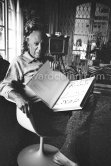 Pablo Picasso with the book "Pablo Picasso at Work" by Edward Quinn, dedicated by Pablo Picasso and Edward Quinn "Pour Jacqueline Kennedy". In the background TV-table by Tiola. Mas Notre-Dame-de-Vie, Mougins 1964. - Photo by Edward Quinn