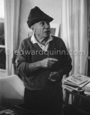 To strike a pose, Pablo Picasso tries on hats from his collection for his own amusement and that of his guests. Mas Notre-Dame-de-Vie, Mougins 1964. - Photo by Edward Quinn