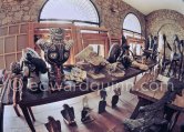 Numerous original ceramics, on the table in the sculpture studio. On the extreme left a carved wooden sculpture, under the table some cutouts and bird figures, against the bay windows stacks of paintings and large canvas frames. Mas Notre-Dame-de-Vie, Mougins 1974. (photographed after Pablo Picasso's death) - Photo by Edward Quinn