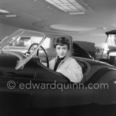 Françoise Sagan evaluating a Jaguar XK120 at the showroom of a Jaguar dealer in Cannes 1954. - Photo by Edward Quinn