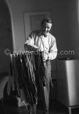 Georges Simenon with his ties at his Villa Golden Gate. Cannes 1955. - Photo by Edward Quinn