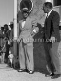 Edward Duke of Windsor and his dog at Nice Airport. The Duke came to the airport to fetch the Duchess of Windsor and then they drove on to the Carlton Hotel in Cannes. Some years before, the Duke and the Duchess had lived nearby at the Château de la Croe which later became the property of Mr. Onassis. In the gardens of the Château there still is a small tombstone in memory of their pet dog, inscribed "Preezie A 
Faithful Little Friend of Edward and Wallis. Duke and Duchess of Windsor". Nice 1954. - Photo by Edward Quinn